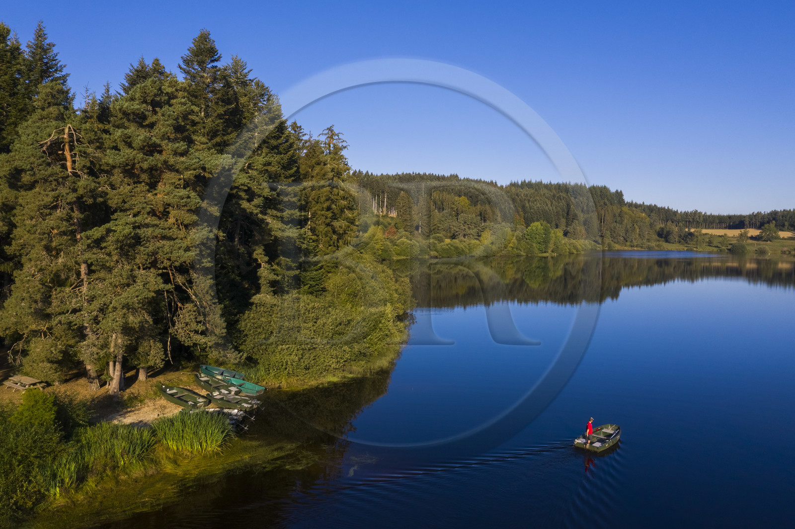 France, Haute Loire, Livradois Forez Regional Natural Park (Parc naturel régional Livradois-Forez), Sembadel, fisherman in boat on the Lake Malaguet (aerial view)