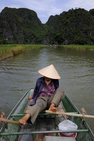 Vietnam, Ninh Binh province nicknamed Inland Halong Bay, small boat trip in Tam Coc surrounded by karstic moutains, rowing with her feet