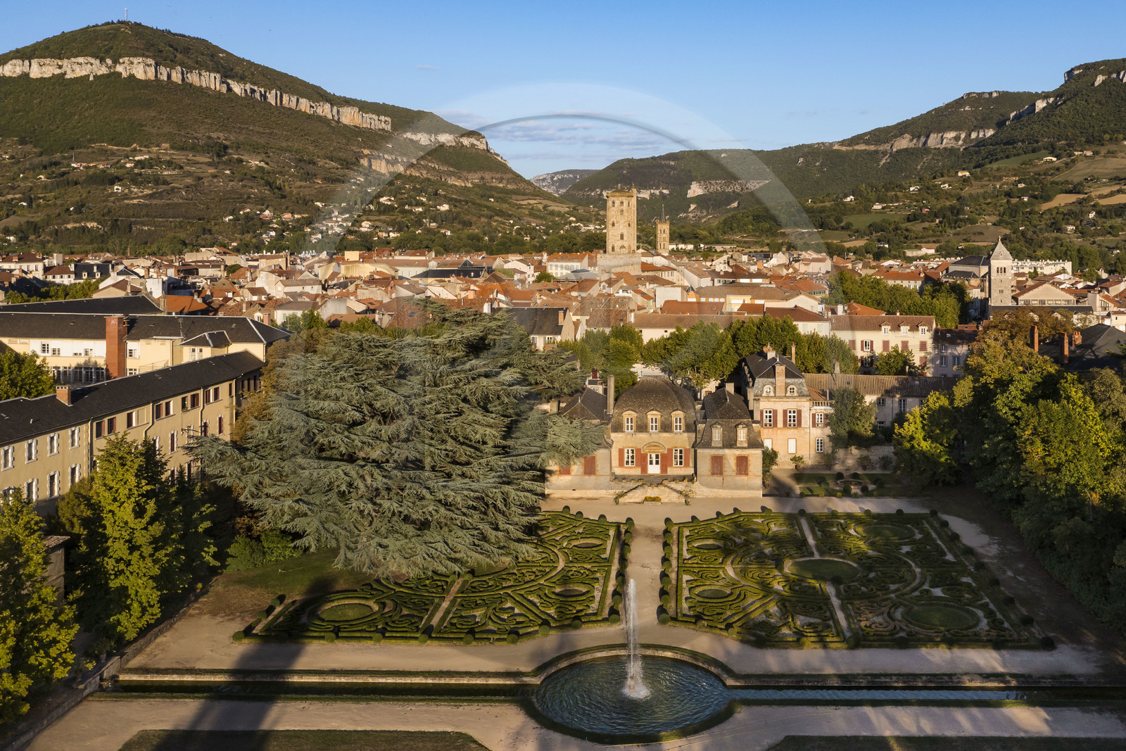 France, Aveyron, the Mansion of Sambucy De Sorgues and its French gardens, the belfry in the heart of the city and et the Puncho d'Agast mountain in the background (aerial view)
