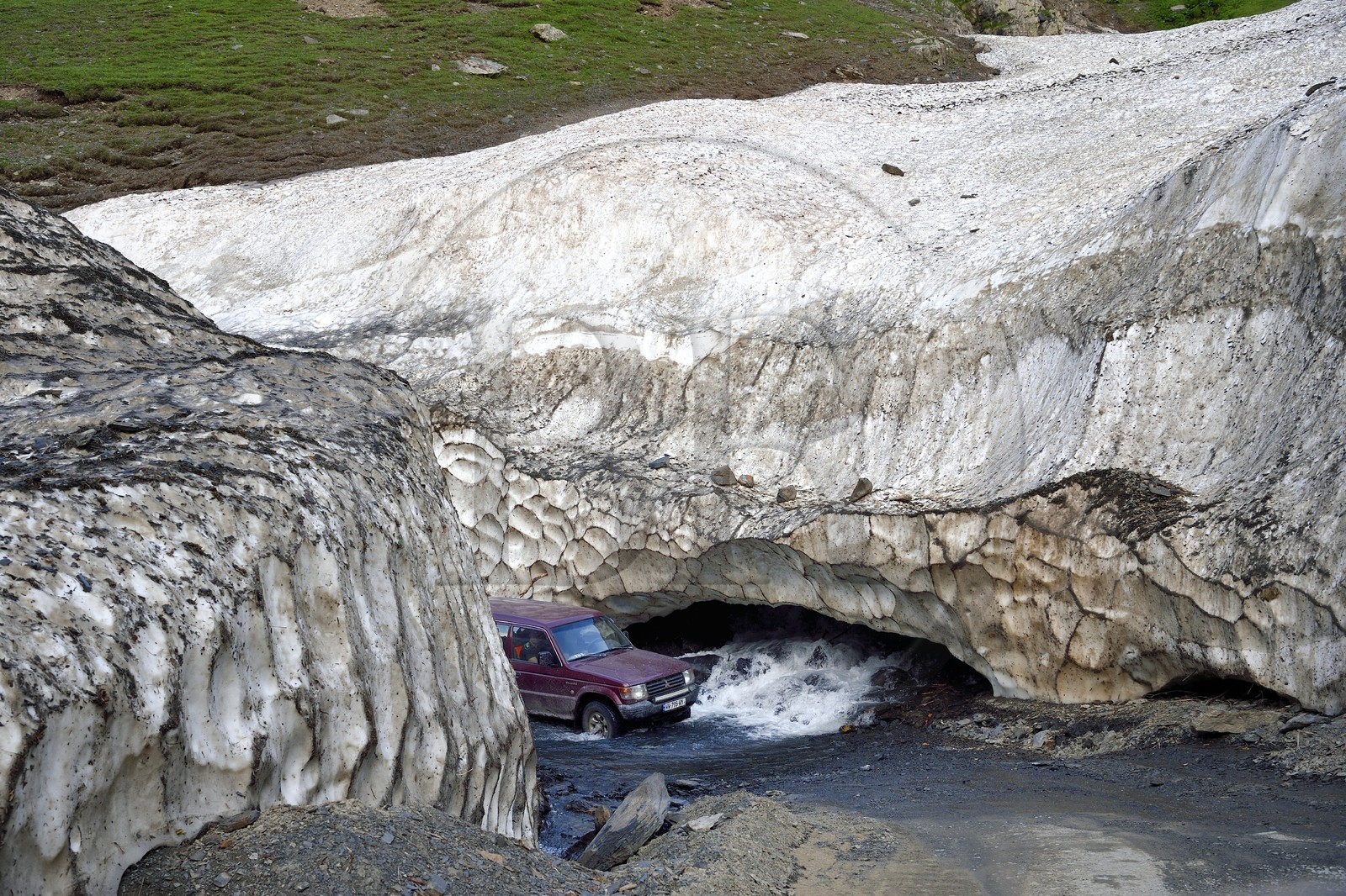 Georgia, Kakheti, Tusheti region, the spectacular track connecting Telavi to Omalo at the Abano Pass (2,826 metres), car crossing the river fording through a firn