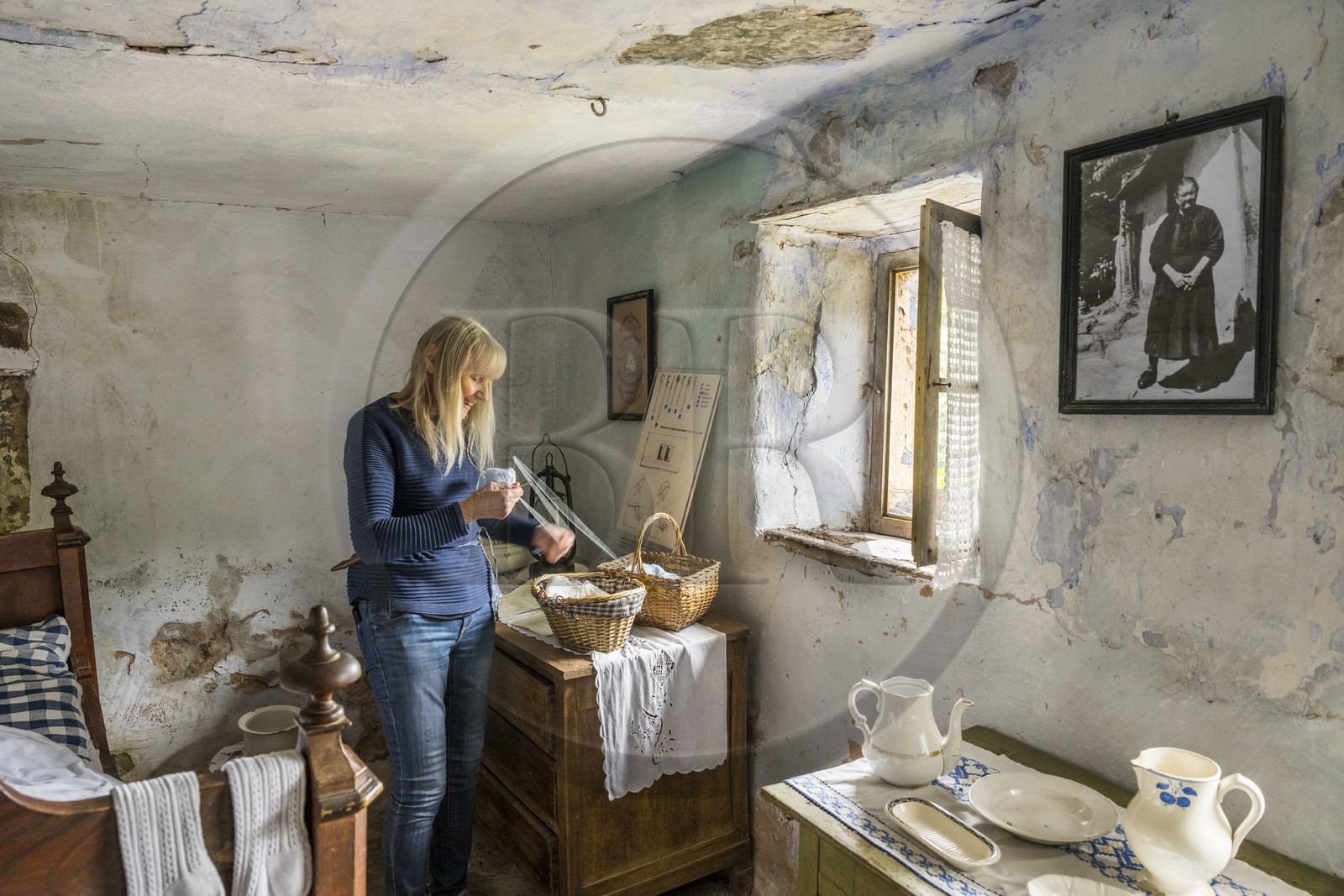 France, Bas-Rhin (67), Parc Naturel régional des Vosges du Nord, Eschbourg, Maisons des Rochers de Graufthal, habitations semi-troglodytiques du XVIIIe siècle et habitées jusqu'en 1958, l'ancienne institutrice du village Annette Oster nous fait une démonstration de l'utilisation d'un affiquet pour tricoter