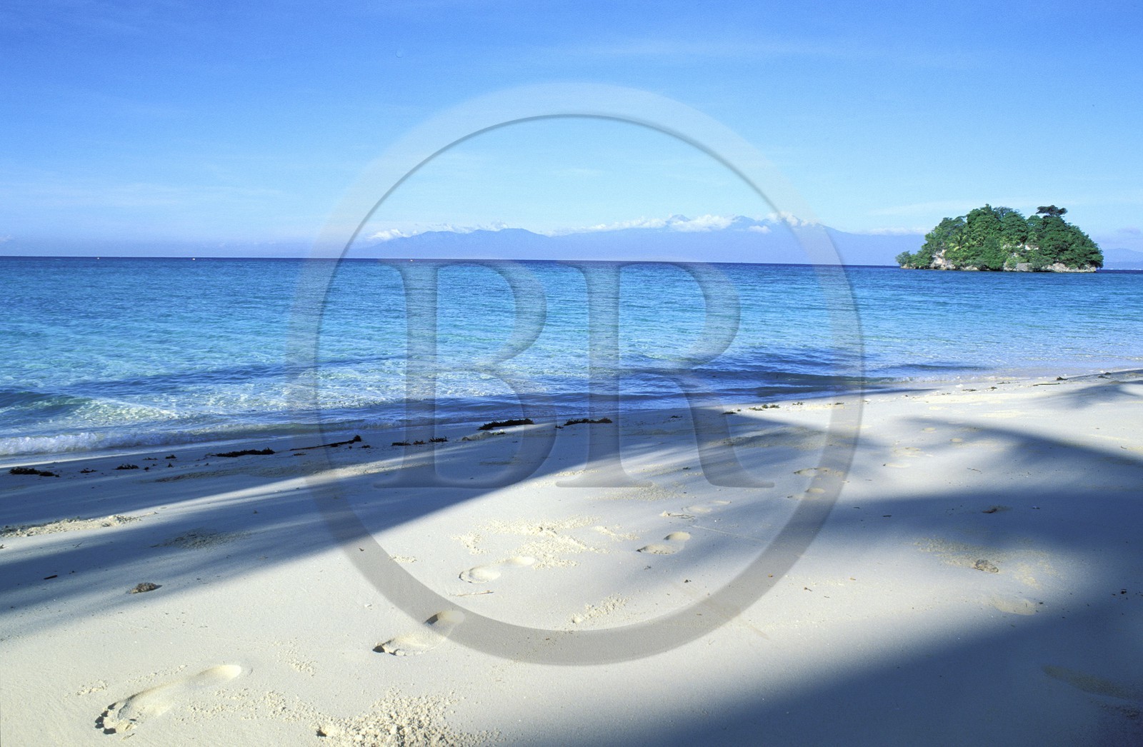 Philippines, île de Mindanao, golfe de Davao, traces de pas sur sable blanc, petite île privée et le volcan Mont Apo