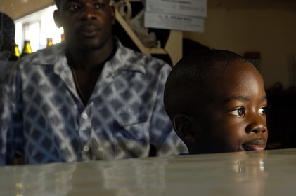 Grenada island, child with his father in a bar in Saint George's (capital city)