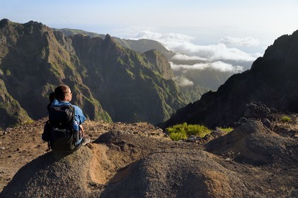 Portugal, Ile de Madère, randonnée sur le Vereda do Areeiro entre les monts Pico Ruivo (1862m) et Pico Arieiro (1817m), randonneuse contemplant la vallée de Faja da Nogueira