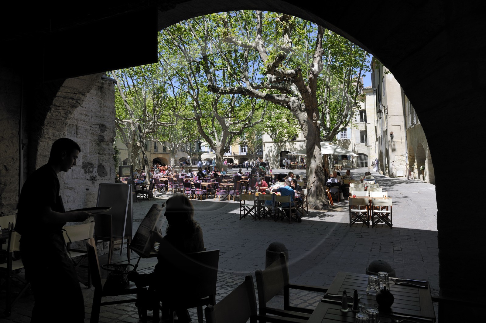 France, Gard (30), Uzès, classée ville d'art et d'histoire, la Place aux Herbes entourée de maisons à arcades et ses terrasses de café
