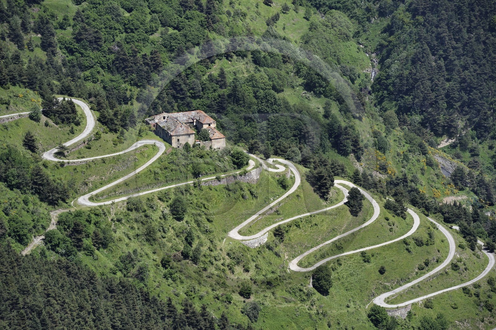 France, Alpes-Maritimes (06), Tende, la vallée de la Roya (arrière-pays niçois) depuis le Col de Tende et les lacets de l'ancienne route du Col de Tende ou passaient les mulets de la route du sel, ancienne auberge qui date de l'époque médiévale
