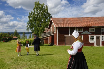 Suède, comté de Dalécarlie, région de Leksand, famille en costumes traditionnels pour les célébrations du solstice d'été dans le petit hameau de Sunnanäng sur la rive du lac Siljan