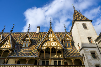 France, Cote d'Or, Beaune, area listed as World Heritage by UNESCO, Hospices de Beaune, Hotel Dieu, multi-colored glazed tile roof protecting the long arcaded gallery in the main courtyard
