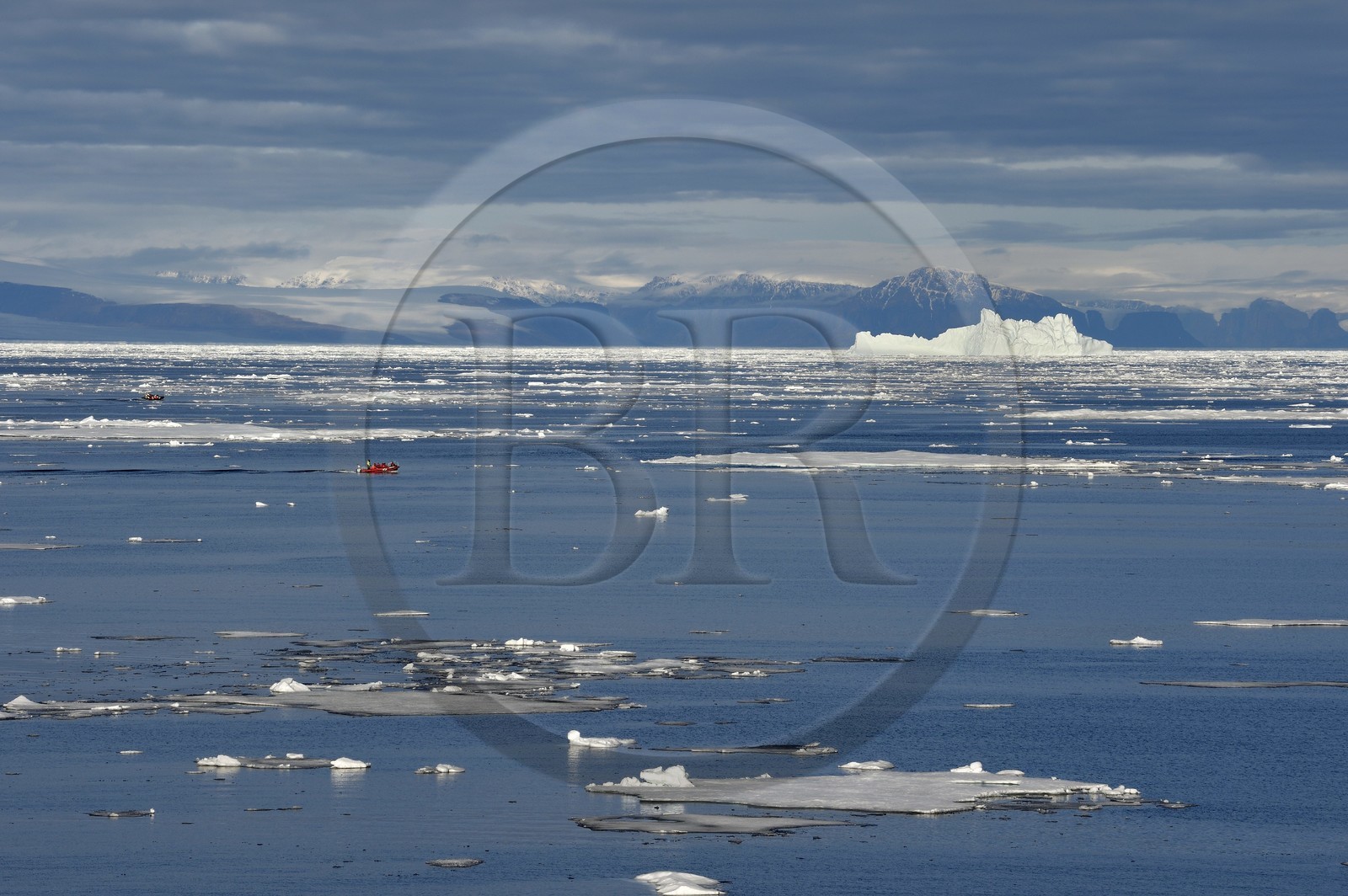 Groenland, cote Nord-Ouest, Smith sound au nord de la baie de Baffin, morceaux de glace de la banquise arctique et un PolarCirkel boat (zodiac) d'exploration du bateau de croisière MS Fram de la compagnie Hurtigruten, iceberg géant en arrière plan vers la côte canadienne de l'ile d'Ellesmere