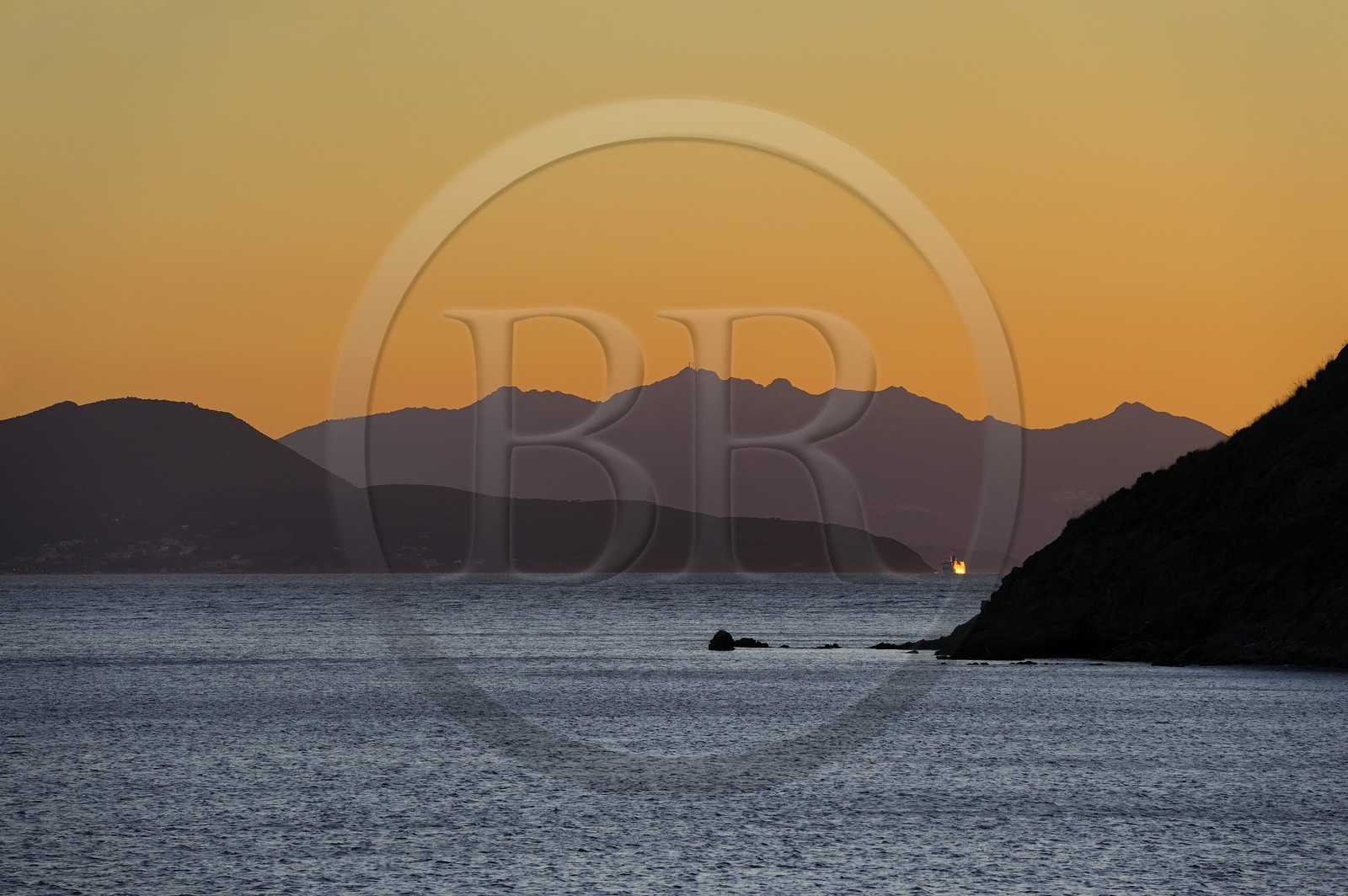 Italie, Toscane, l’Ile d’Elbe au coucher de soleil et la côte à Piombino en premier plan