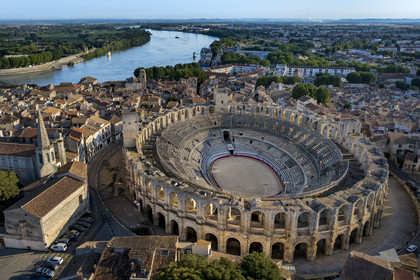 France, Bouches du Rhone, Arles, the Arena, a Roman amphitheater built around 80-90 AD, listed as World heritage by UNESCO, in the heart of the old town, the church of the Cordeliers convent on the left and the Rhone river in the background (aerial view)