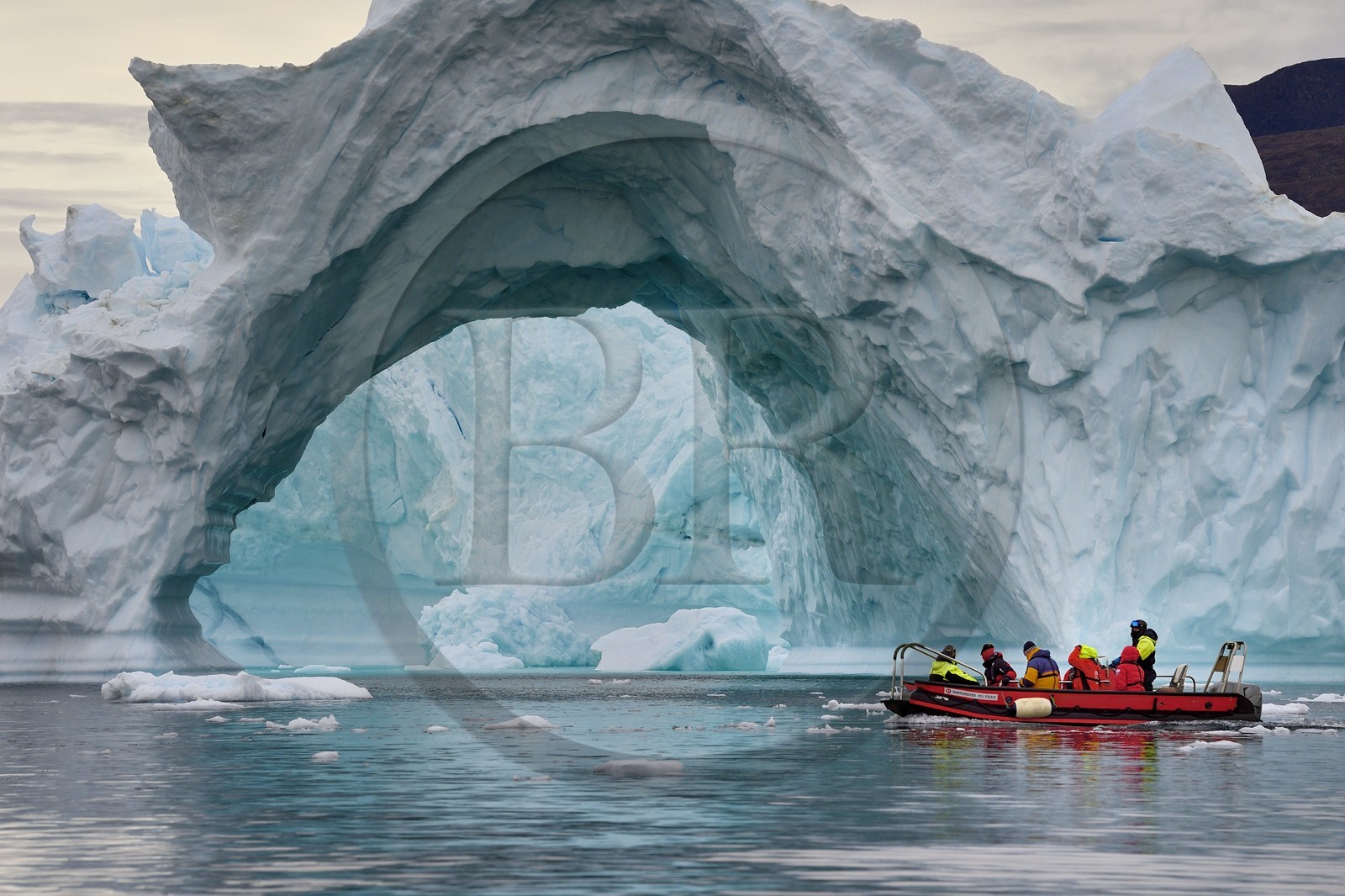 Groenland, cote Nord-Ouest, mer de Baffin, Inglefield Fjord vers Qaanaaq, iceberg formant un arche et un PolarCirkel boat (zodiac) d'exploration du bateau de croisière MS Fram de la compagnie Hurtigruten