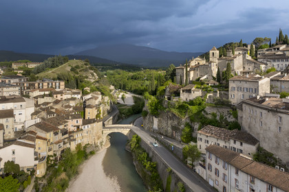 France, Vaucluse, Vaison la Romaine, the Roman bridge over the Ouveze river dating from the 1st century AD which links the lower town and the medieval town on the right, the Mont Ventoux in the background (aerial view)