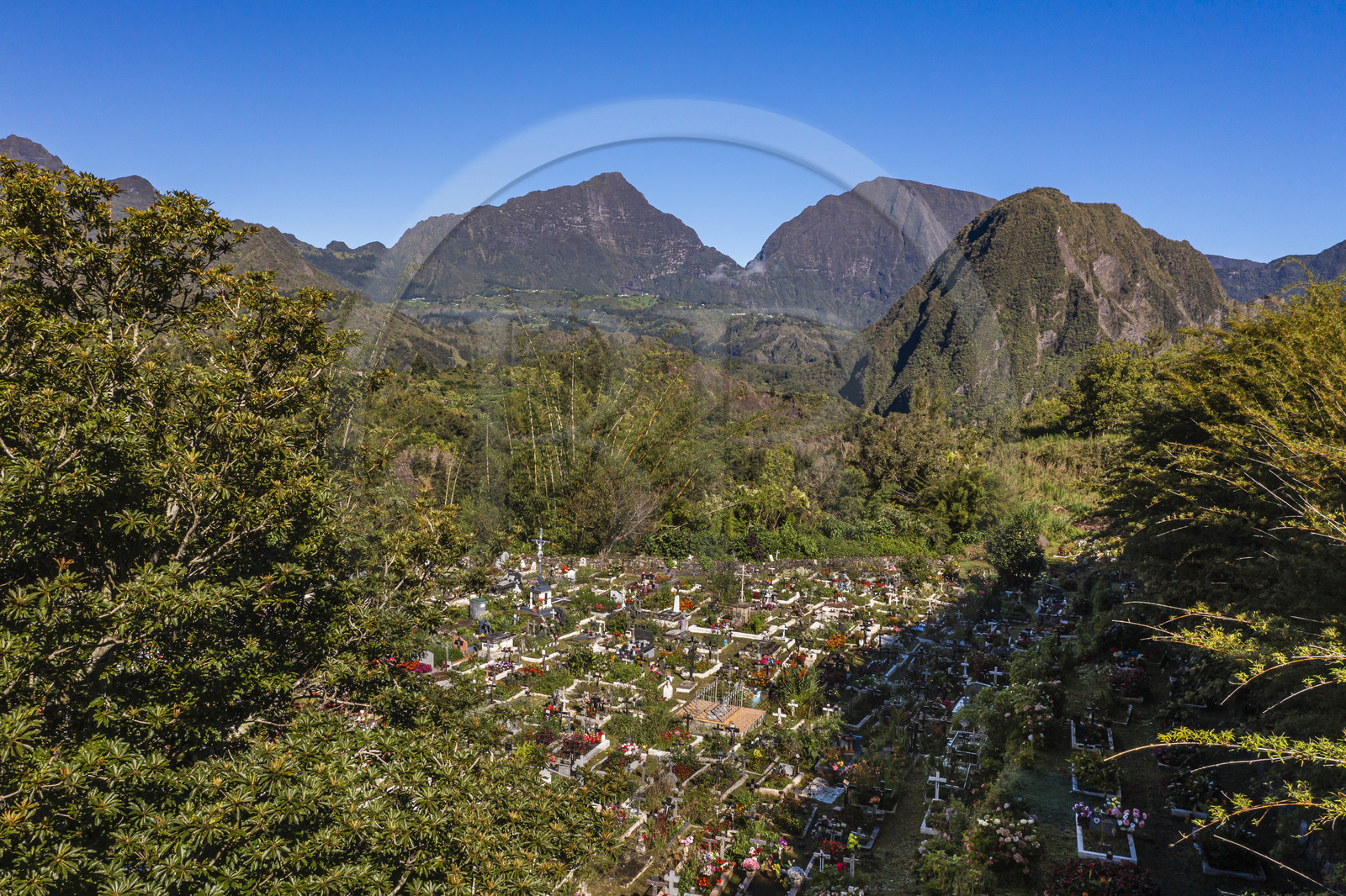 France, Ile de la Reunion, Cirque de Salazie, classé Patrimoine Mondial de l'UNESCO, Hell-Bourg, labellisé les Plus Beaux Villages de France, le cimetière constitué de tombes en pleine terre fleuries naturellement, le Piton d'Anchaing en arrière plan (vue aérienne)