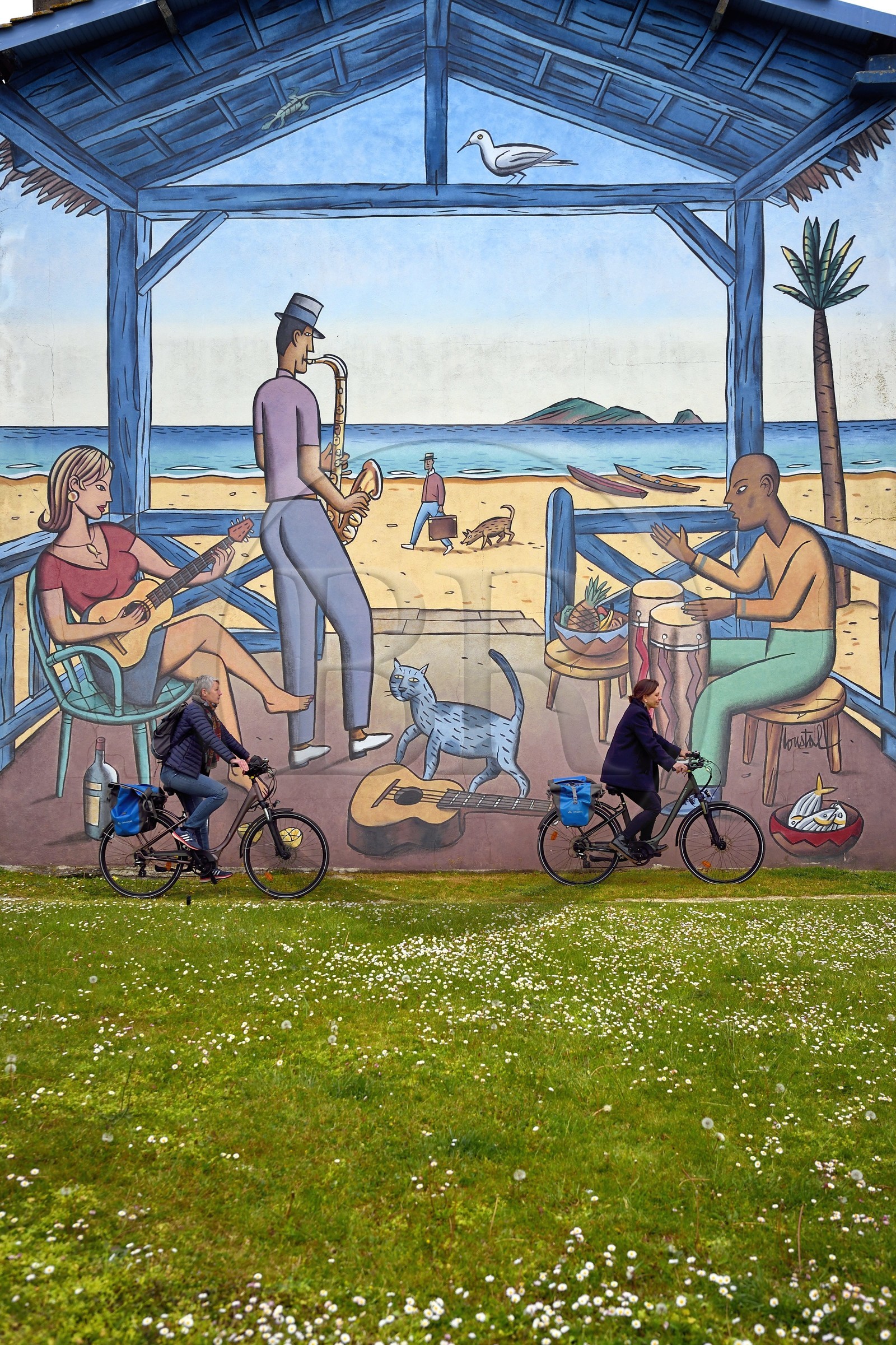 France, Charente, Angouleme, Place de la Madeleine, cyclist doing the cycle route La Flow Vélo in front of La Guitariste, wall painted from an original drawing by Loustal and made by the Cité de la Création in 2005