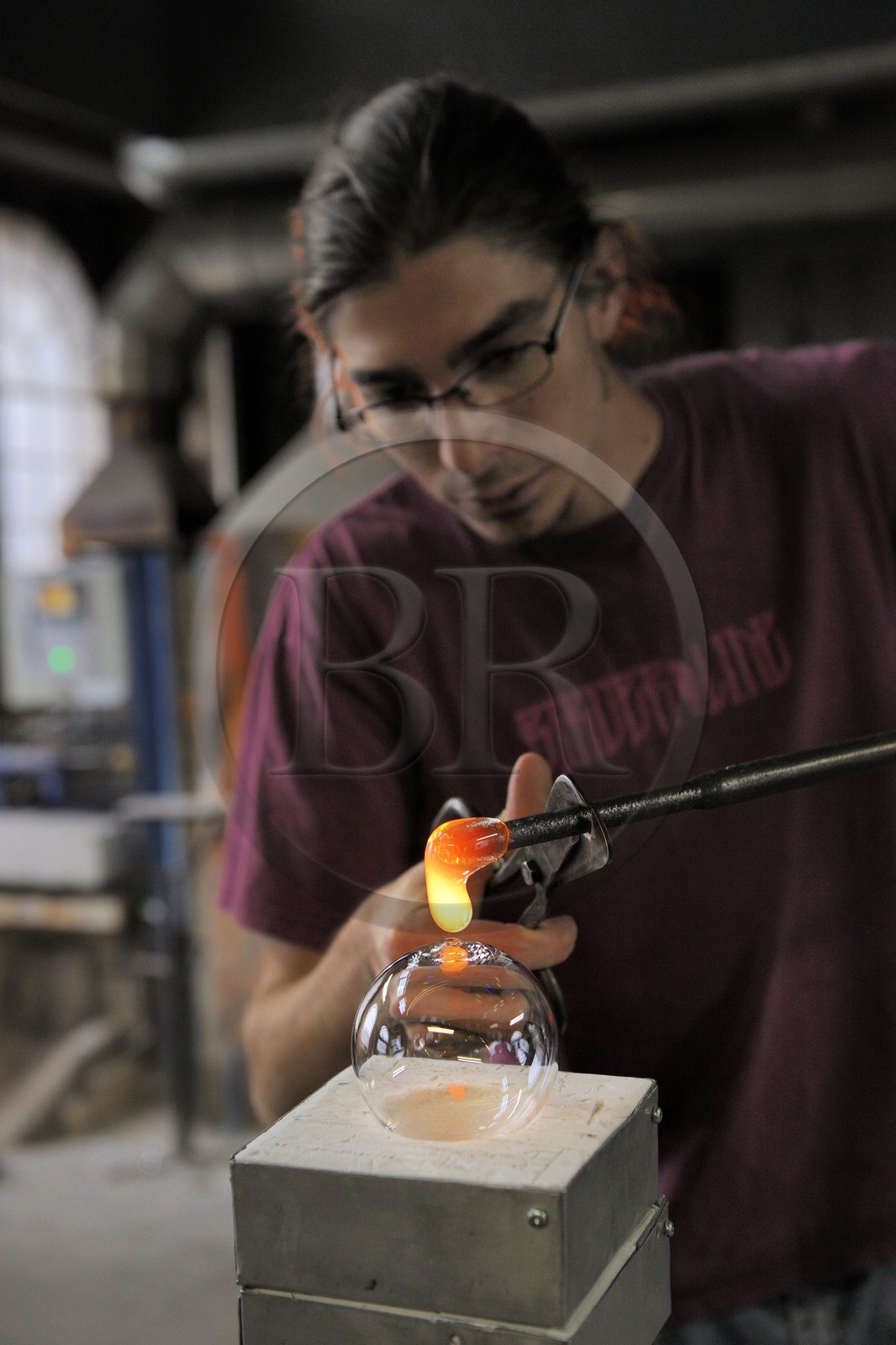 France, Moselle (57), Meisenthal, Thibaut souffleur au Centre international d’Art verrier (CIAV), fabrication d'une boule de Noël en verre. Avec du verre en fusion, il colmate directement le trou – l’impact où la boule a été soufflée