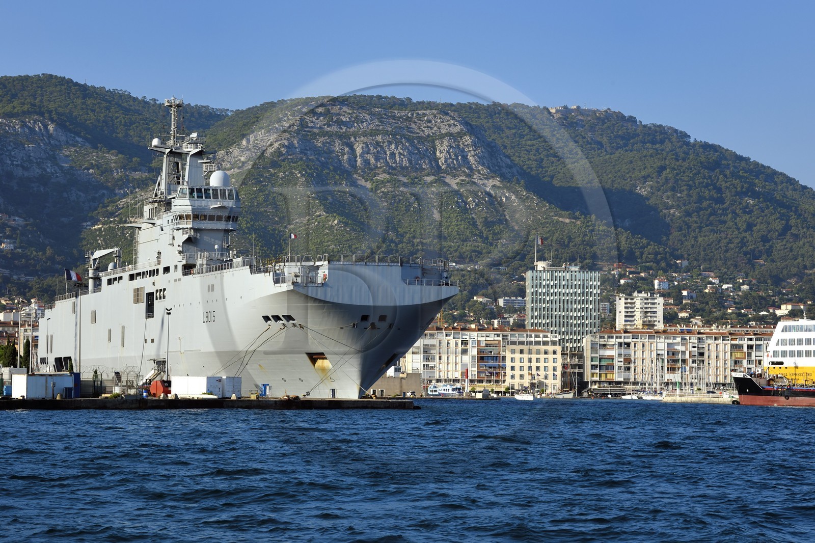 France, Var (83), Toulon, la base navale (Arsenal), Le Dixmude (L9015) est un batiment de projection et de commandement (BPC) de la Marine Nationale de la classe Mistral, en arrière plan l'immeuble de la mairie et le port civil