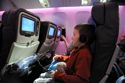 France, vol long-courrier en classe économique entre Paris et l'île de la Réunion, enfant jouant à un jeu video