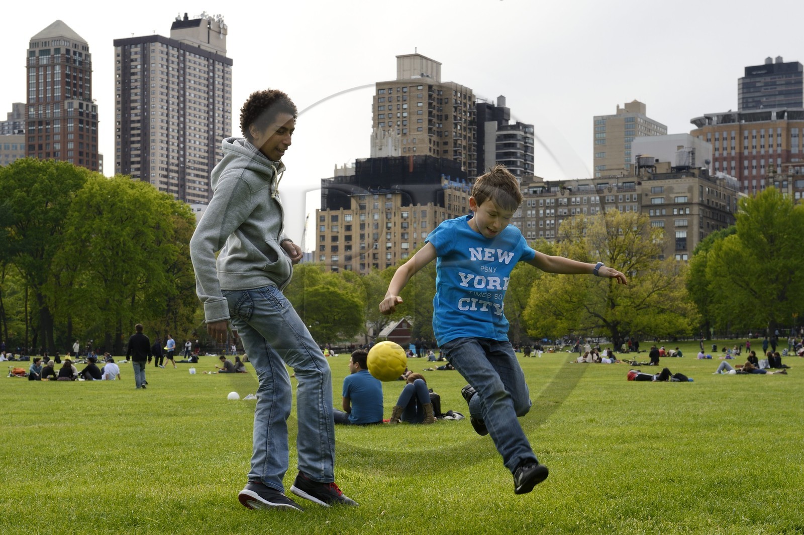 Etats-Unis, New York, Manhattan, Central Park, enfants jouant au football sur le Sheep Meadow, immeubles de Central Park Sud en arrière plan