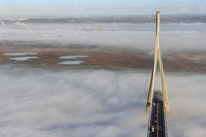 France, entre Calvados (14) et Seine-Maritime (76), le Pont de Normandie enjambe la Seine et émerge d'une mer de nuages, la Réserve Naturelle de l'estuaire de la Seine en arrière plan