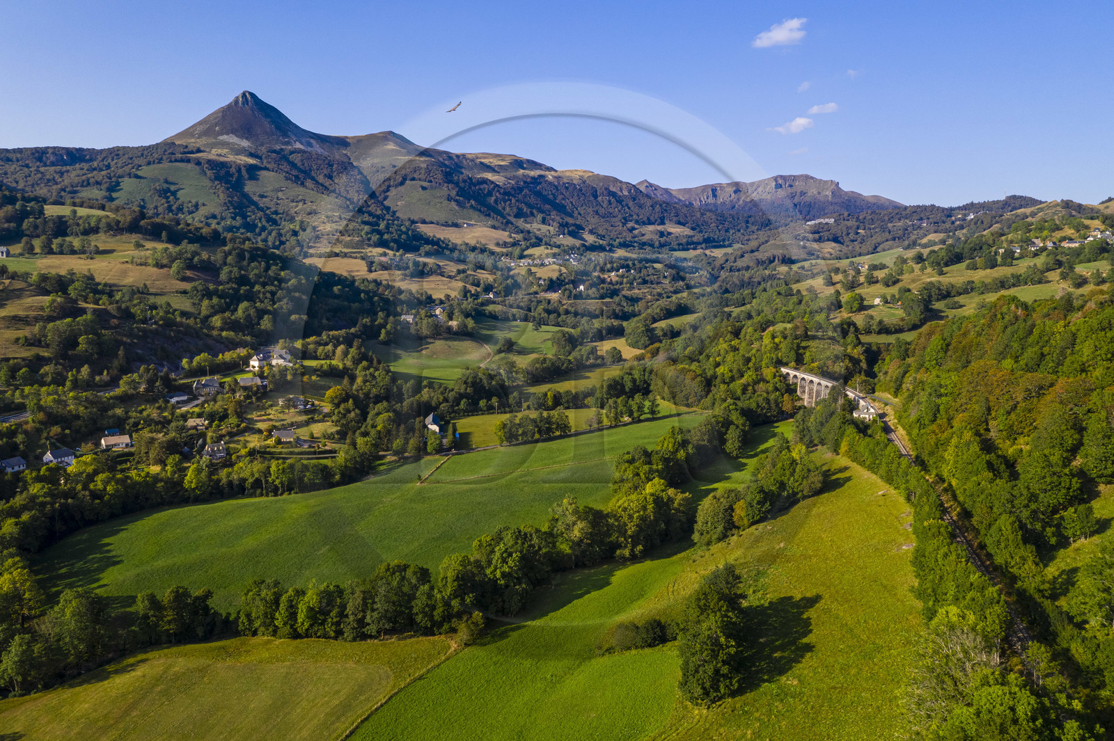 France, Cantal, Parc Naturel Régional des Volcans d'Auvergne (regional nature park of Auvergne volcanoes), Saint Jacques des Blats on the Way of St. James to Santiago de Compostela by Via Arverna, the valley of the Cère, in the background from left to right the Puy Griou, the col de Rombière, the summit of Téton de Venus and the Rocher du Bec de l'Aigle (aerial view)