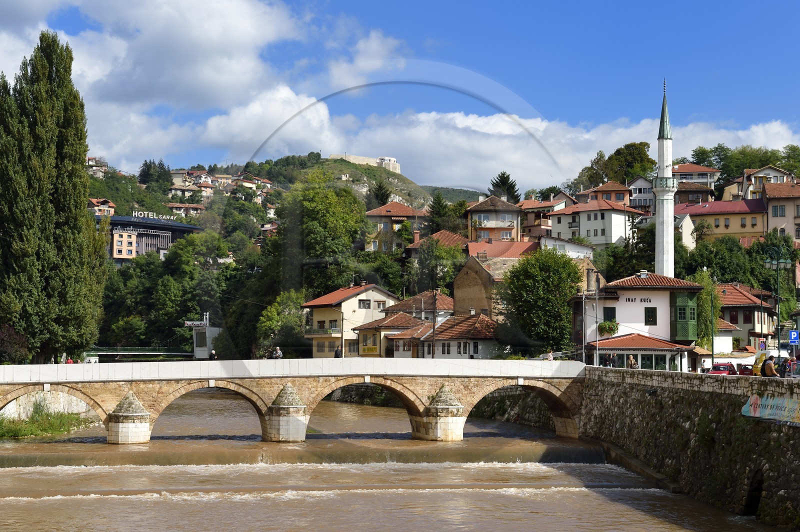 Bosnie-Herzégovine, Sarajevo, le pont Seher Cehaja sur la rivière Miljacka et la Maison du Défi à droite devant le minaret