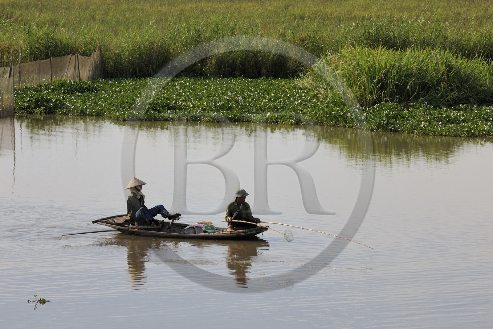 Vietnam, province de Ninh Binh, pêcheurs sur un canal, ramant avec ses pieds