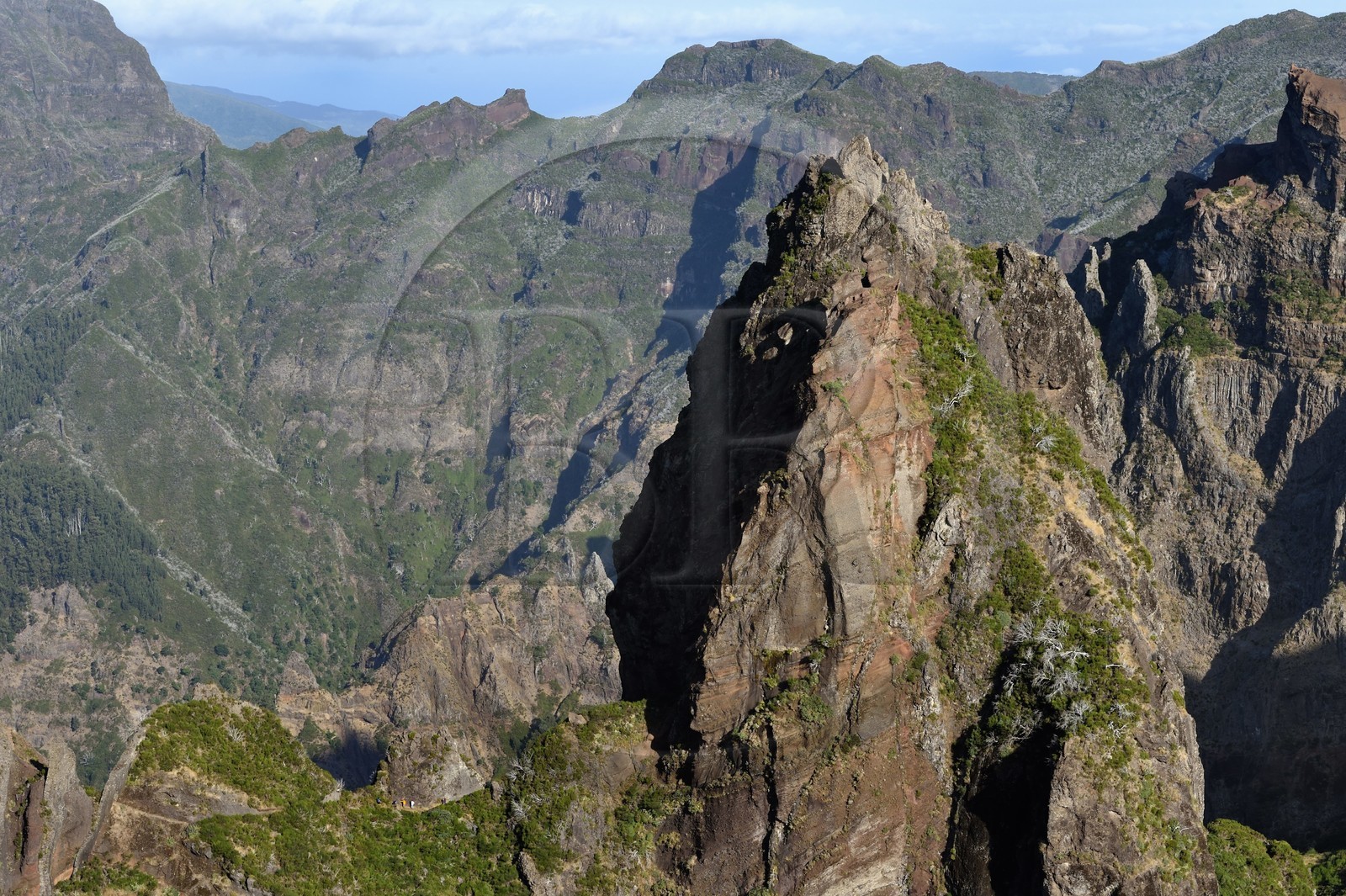 Portugal, Madeira Island, hikers on the Vereda do Areeiro hike between Pico Ruivo (1862m) and Pico Arieiro (1817m), view from Ninho da Manta (buzzard's nest) belvedere over the central mountain range