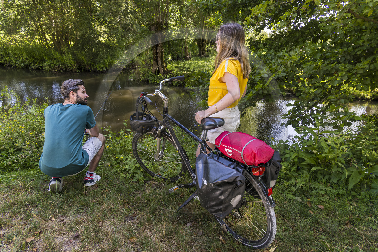 France, Deux-Sèvres (79), le Marais Poitevin, la Venise Verte, Le Vanneau-Irleau, randonnée à bicyclette le long des canaux, un des cyclistes se lance dans la pêche à la ligne
