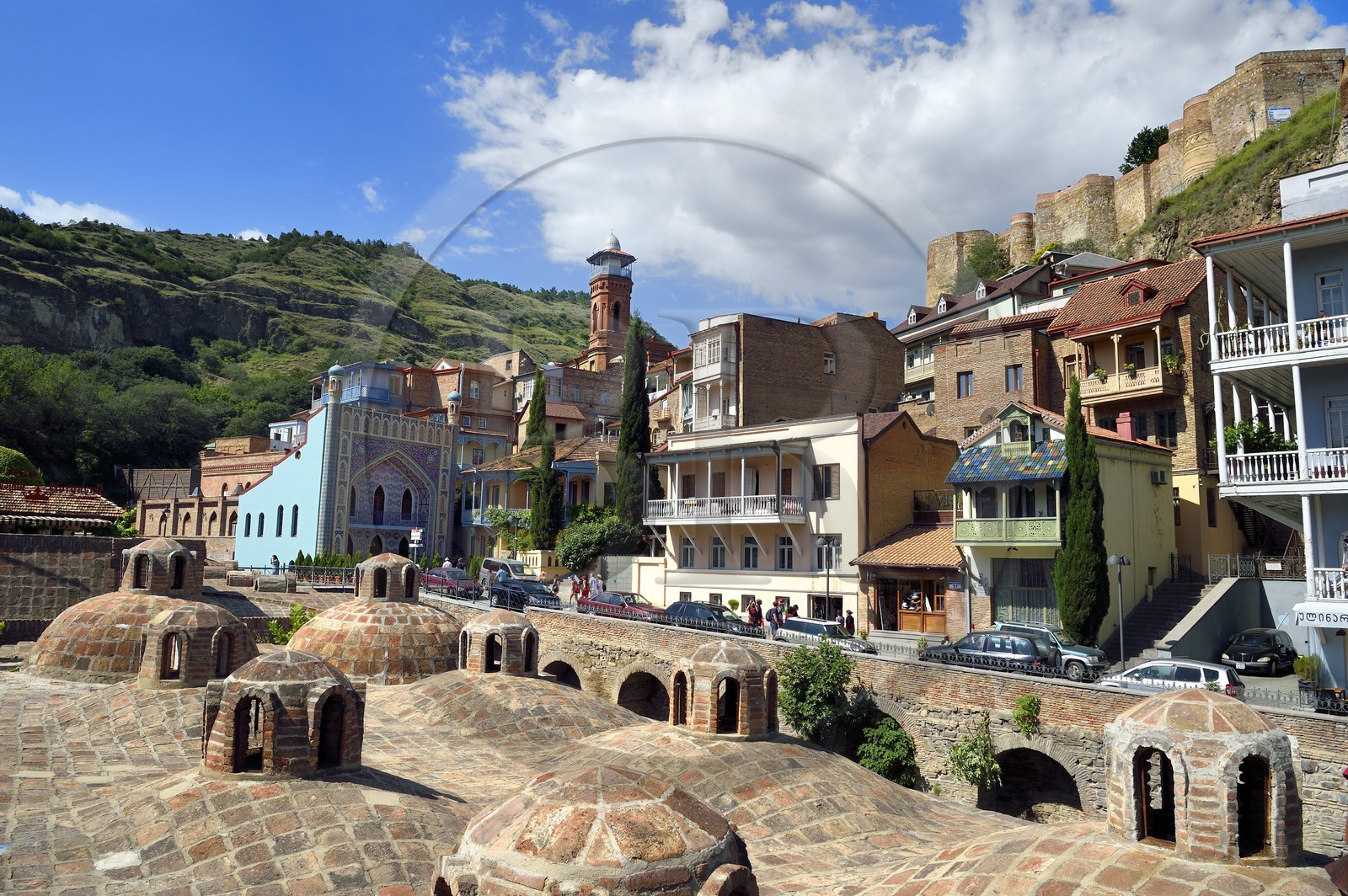 Georgia, Tbilisi, Old City, thermal district of Abanotoubani with the roofs of public sulfur baths, the Orbeliani Baths with the blue tiled facade, the minaret of the mosque and the Narikala fortress (4th century) in the background