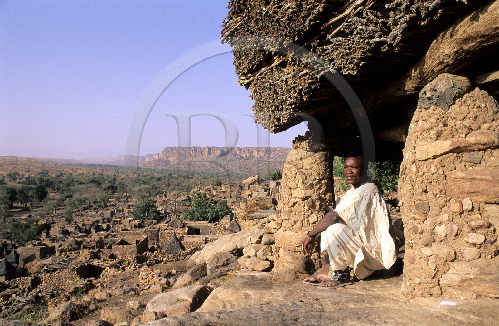 Mali, Dogon Country, village of Tereli, a man sitting under the Toguna (talking hut) overlooking the Bandiagara Cliff, listed as World Heritage by UNESCO