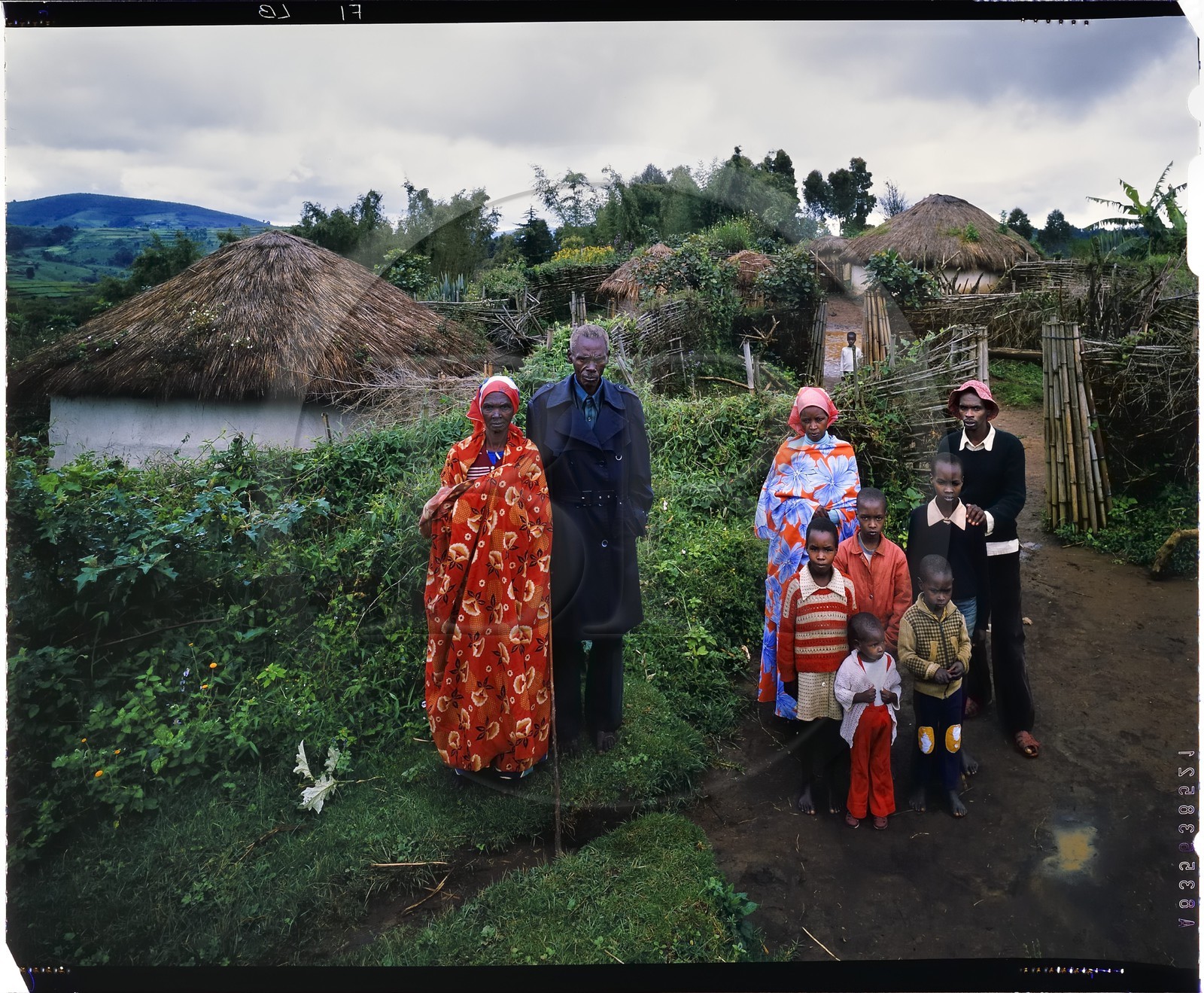 Burundi, Bujumbura Province, Ijenda area, Tutsi family in front of their rugo (traditional farmhouse) of archaic type, in the foreground right we see the enclosure where the cows are locked up for the night (forecourt), on the left we can see the hut of a married son whose access is via the main courtyard and in the background is the main courtyard with the head of rugo hut and the granaries (4x5 reversal film reproduction)