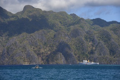 Philippines, Calamian Islands dans le nord de Palawan, Coron Island Natural Biotic Area, navire-école pour les cadets de l'Académie Maritime de l'Asie et du Pacifique au pied des murs géants des falaises de calcaire