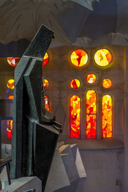 Espagne, Catalogne, Barcelone, quartier de l'Eixample, basilique de la Sagrada Familia de l'architecte du modernisme catalan Antoni Gaudi classée Patrimoine Mondial de l'UNESCO, statue en bronze de Saint Georges (Sant Jordi) par le sculpteur Subirachs au centre de l'intérieur de la facade de la Gloire et le côté facade de la Passion de la Nef aux vitraux aux couleurs chaudes