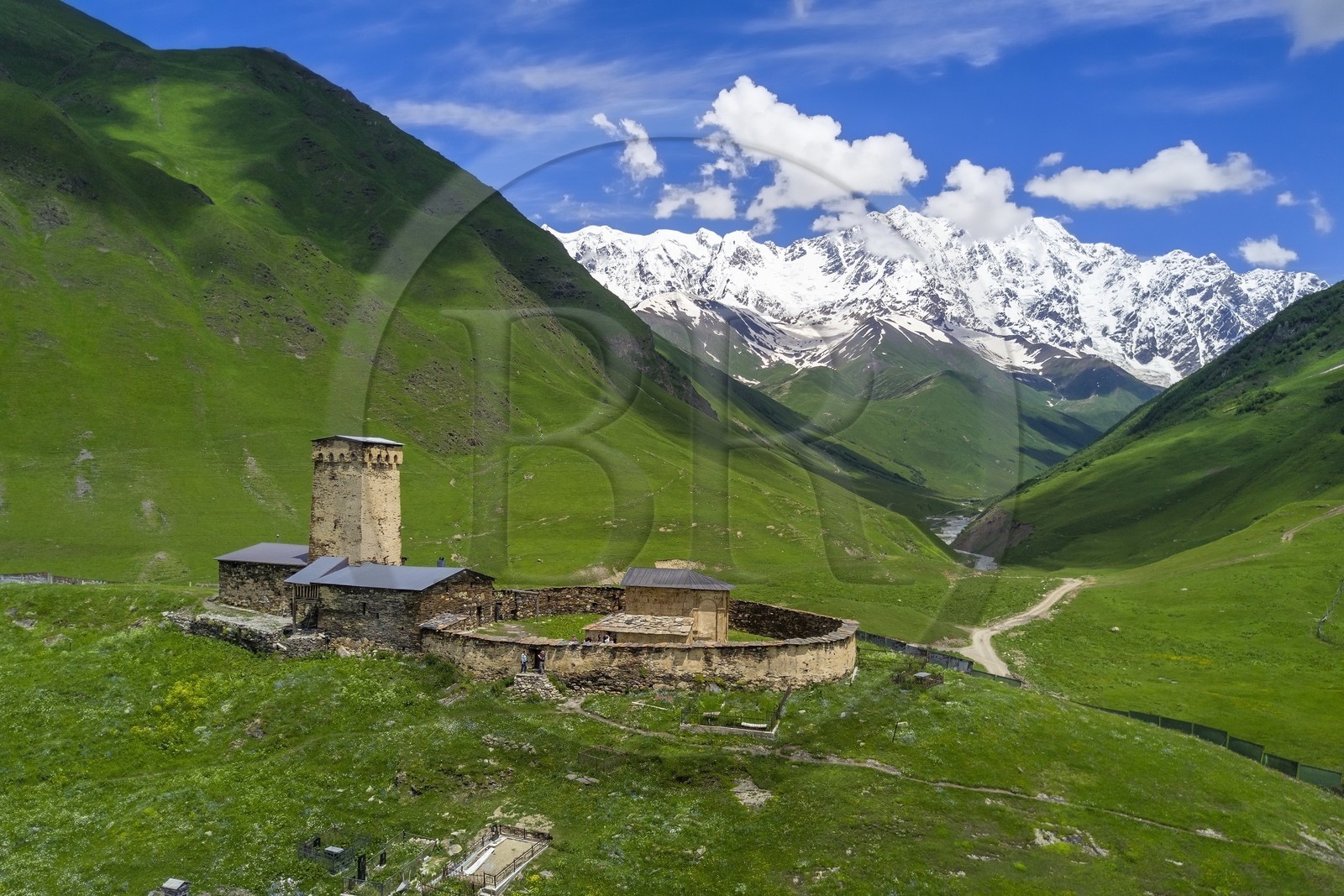 Géorgie, Haute Svanétie (Zemo Svaneti), village de Ushguli (Ouchgouli), classé Patrimoine Mondial de l'UNESCO, église Lamaria Sainte-Marie d'Ushguli du XIIème siècle et le mont Chkhara (plus haut sommet de Georgie avec 5193 m) en arrière plan (vue aérienne)