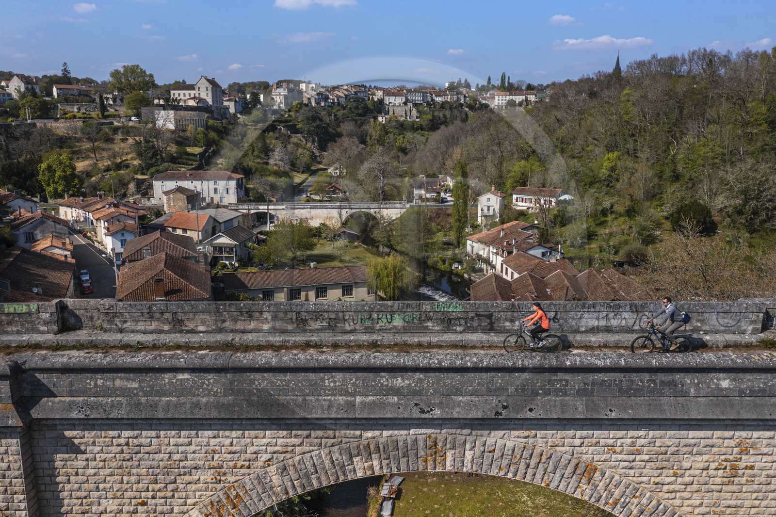 France, Dordogne, Périgord Vert, Nontron, cyclists traveling along the Flow Vélo cycle route on the former railway viaduct which crosses the Bandiat river valley, the town in the background (aerial view)