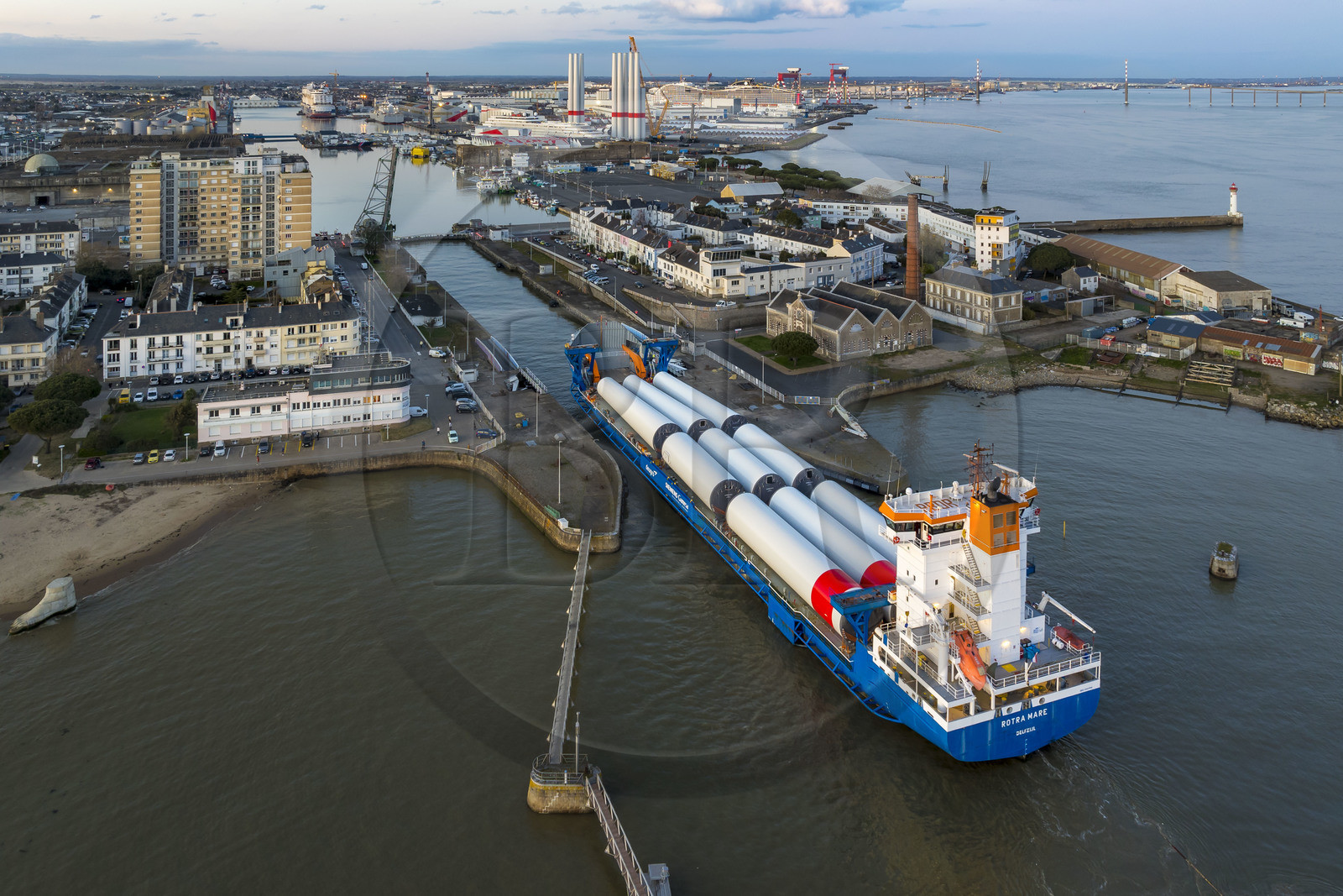 France, Loire Atlantique, Saint Nazaire, The General Cargo Rotra Mare transports sections of wind turbine masts and enters the port's wet dock (in the background) via the south lock, which was also the site of Operation Chariot launched in 1942 by the British (aerial view)