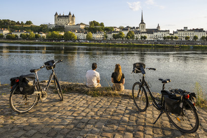 France, Maine-et-Loire, Loire valley listed as World Heritage by UNESCO, Saumur, cycling on the banks of the Loire, the castle and the church of Saint-Pierre on the banks of the Loire river