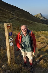 France, Cantal (15), Parc Naturel Régional des Volcans d'Auvergne, Le Lioran, col de Rombière, Bernard Quinsat qui a imaginé dans les années 2000 la Via Arverna sur le chemin de Saint-Jacques de Compostelle et fondateur de la maison d’édition de guides Chamina, le Griounou en arrière plan