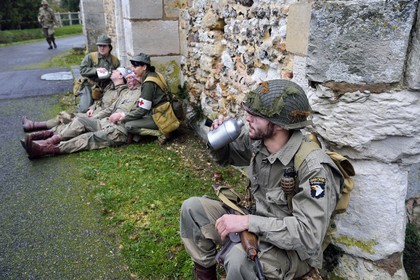 France, Eure (27), Chambray, Allied Reconstitution Group (association de reconstitution historique de la 2éme Guerre Mondiale US et Maquis), reconstitueurs en uniforme de la 101e division aéroportée US au repos devant l'église
