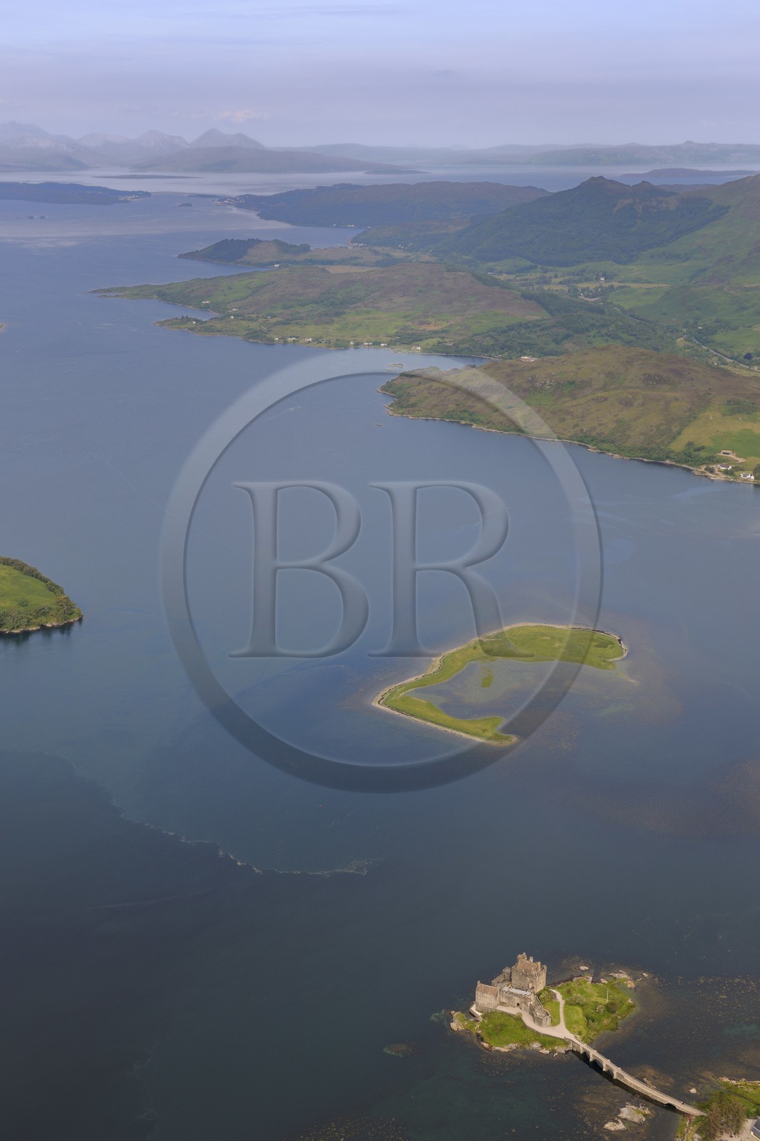 Royaume-Uni, Ecosse, Highland, Dornie, Eilean Donan castle dans le Loch Alsh et l'Ile de Skye en arrière plan (vue aérienne)