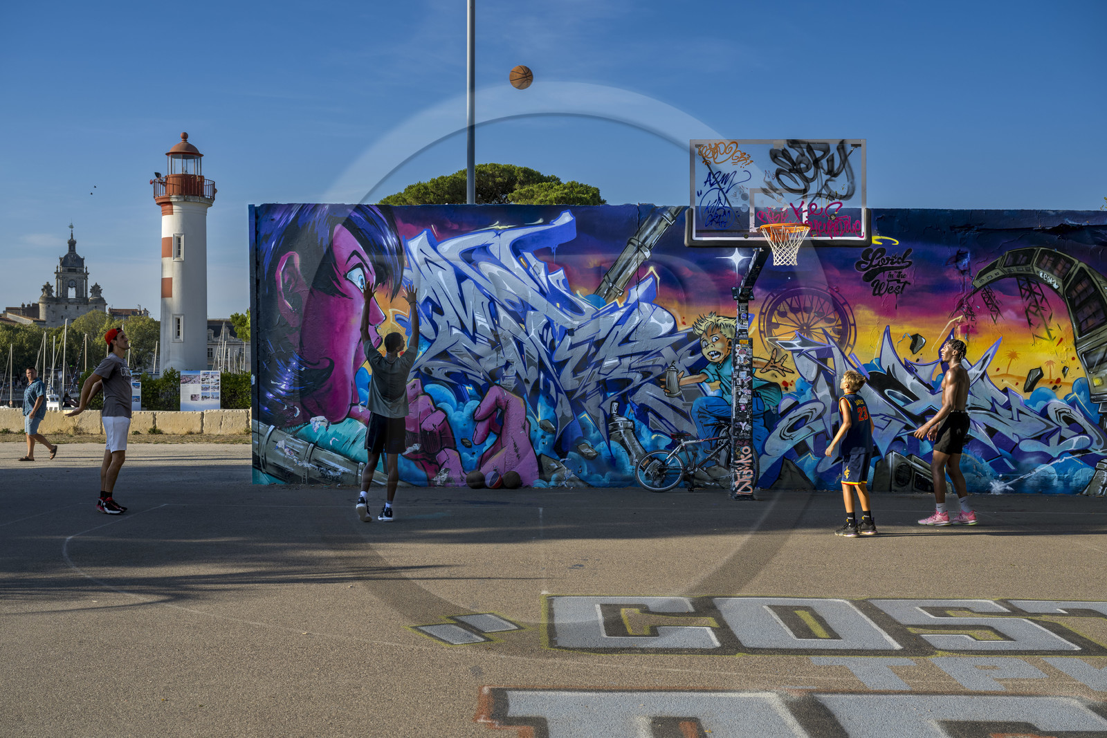 France, Charente Maritime, La Rochelle, the Old Port lighthouse the red lantern in the Gabut district and street art on the basketball court