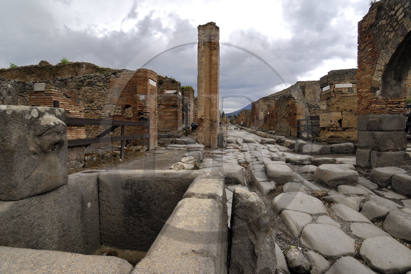Italy, Campania, Pompei, archeological site listed as World Heritage by UNESCO, old paved street of the city and fountain