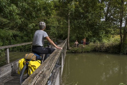 France, Charente-Maritime (17), Saint-Agnan, cycliste sur la véloroute en direction de l'abbaye de Trizay, rencontre avec des pêcheurs en bordure du petit canal de Pont-l'Abbé dans la vallée de l’Arnoult