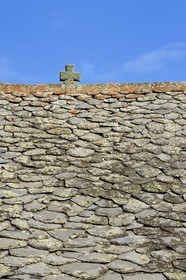 France, Cantal (15), Parc Naturel Régional des Volcans d'Auvergne, étape sur le chemin de Saint-Jacques de Compostelle par la Via Arverna, Chalinargues, hameau de Mons, la croix en pierre surmontant le toit des maisons couvertes en lauze est l’un des grands thèmes traditionnels de protection