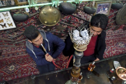 Iran, province d'Ispahan, Ispahan, la maison de thé et restaurant Chai Khaneh Azadegan, homme fumant la pipe à eau