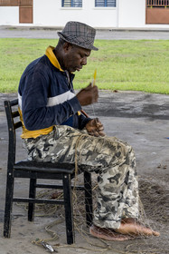 France, Guyane, Kourou, pêcheur reprisant son filet