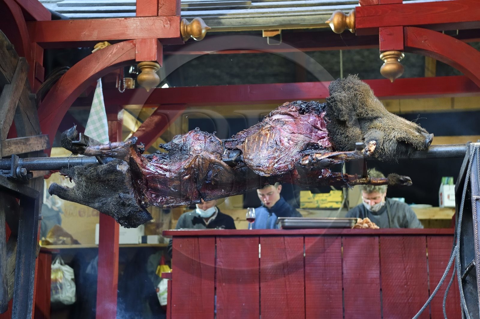 France, Haut Rhin, Strasbourg, Ribeauvillé, the medieval christmas market, stall offering wild boar on the spit accompanied by cervoise and wine