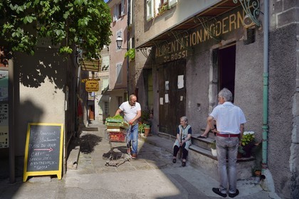 France, Alpes de Haute Provence, Entrevaux Medieval city fortified by Vauban, discussion in front of the old town grocery store in la Porte Royale street