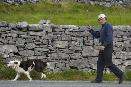 Republic of Ireland, County Galway, Aran Islands, Inishmore, man and his dog